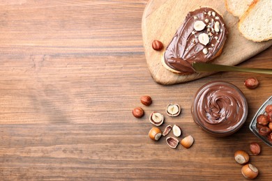 Flat lay composition with tasty chocolate hazelnut spread on wooden table, space for text