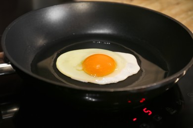 Photo of Cooking egg for tasty breakfast in frying pan