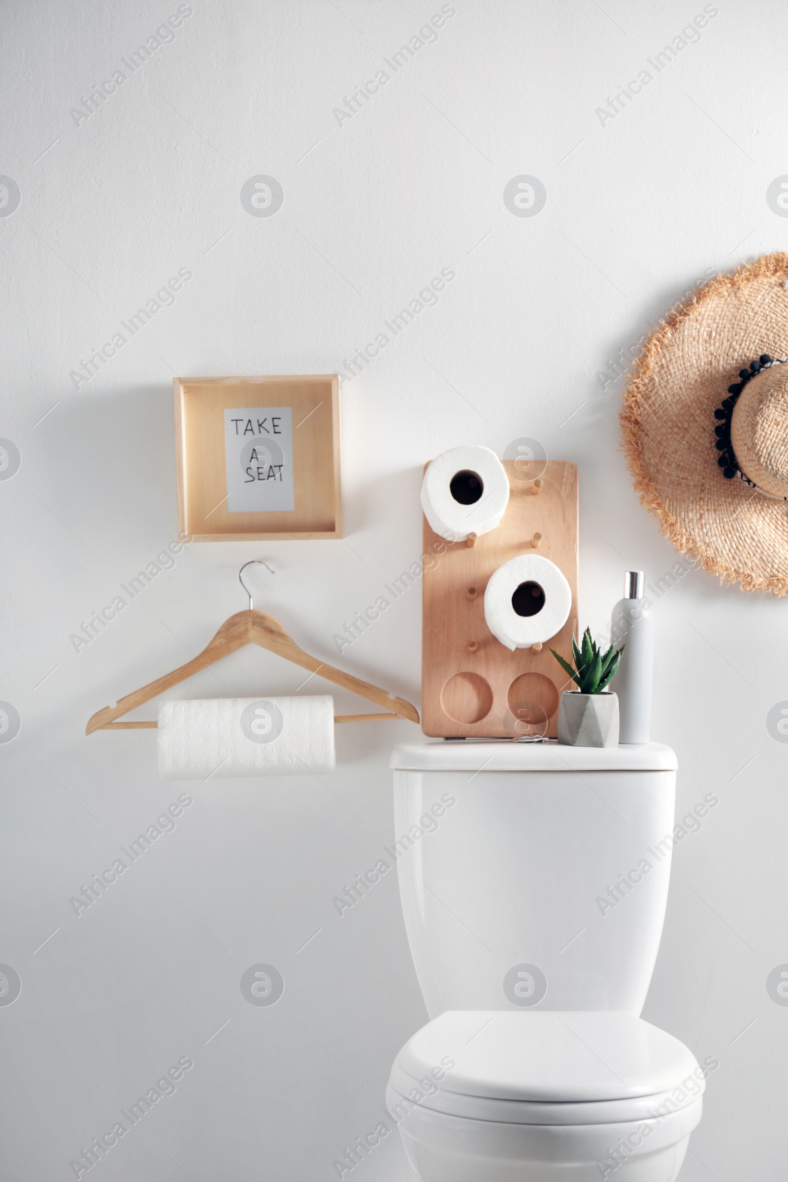 Photo of Decor elements, necessities and toilet bowl near white wall. Bathroom interior