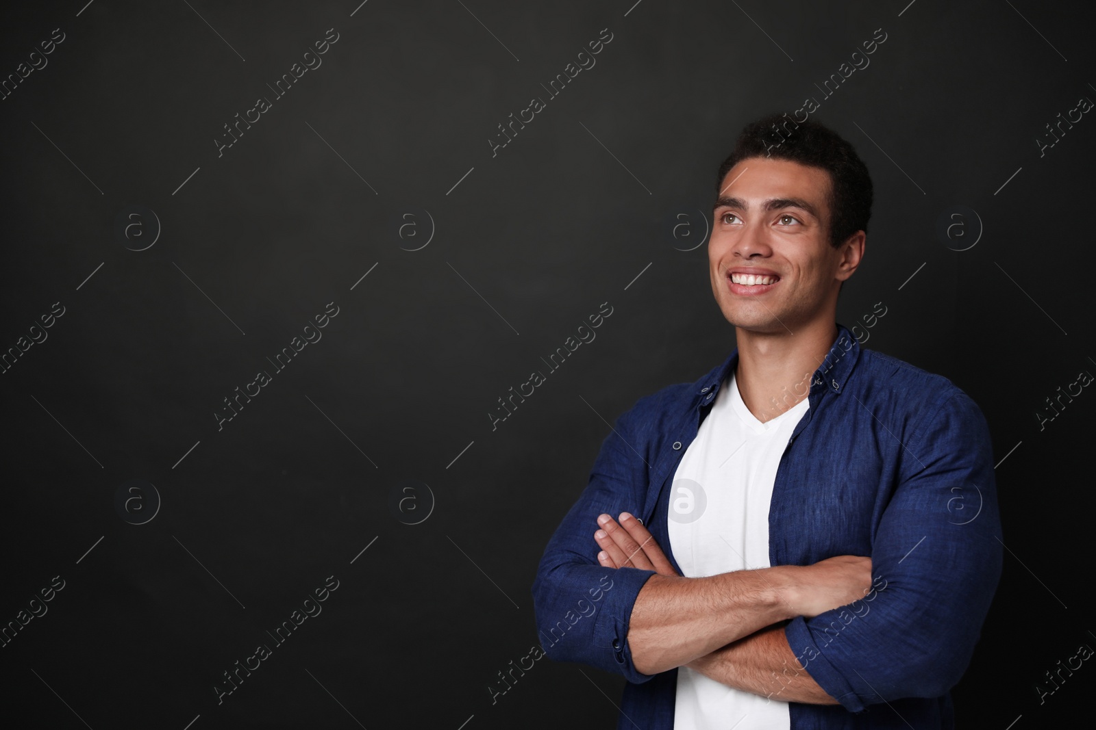 Photo of Handsome young African-American man on black background. Space for text