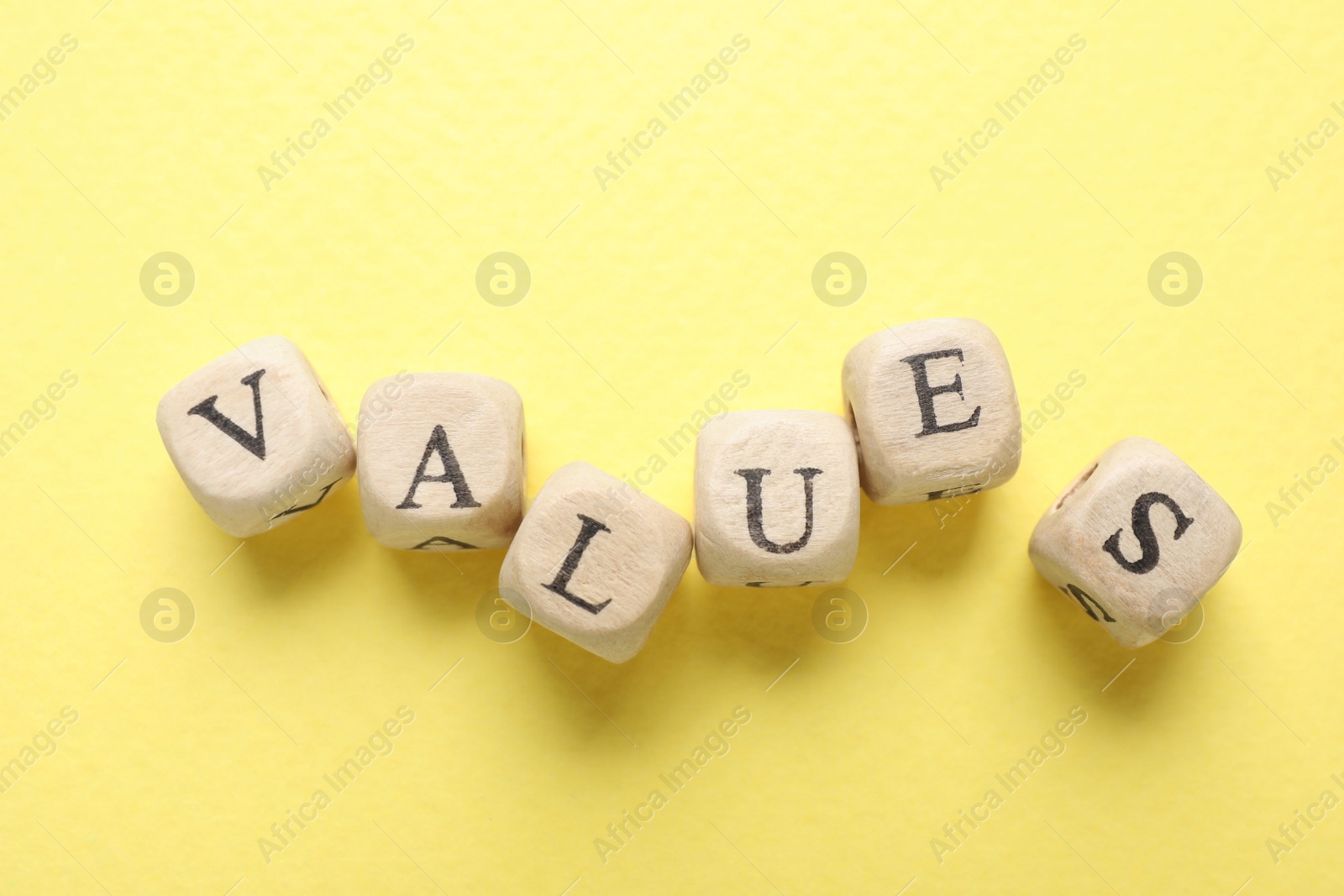 Photo of Beads with word VALUES on yellow background, flat lay