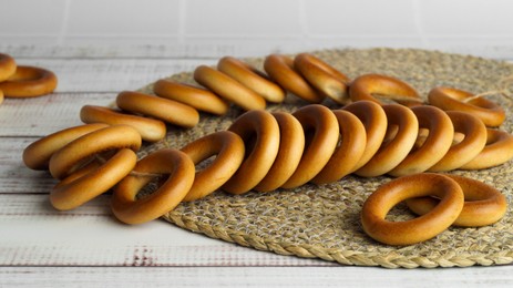Photo of Bunch of delicious ring shaped Sushki (dry bagels) on white wooden table