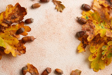 Photo of Frame of autumn leaves and acorns on color background, flat lay. Space for text