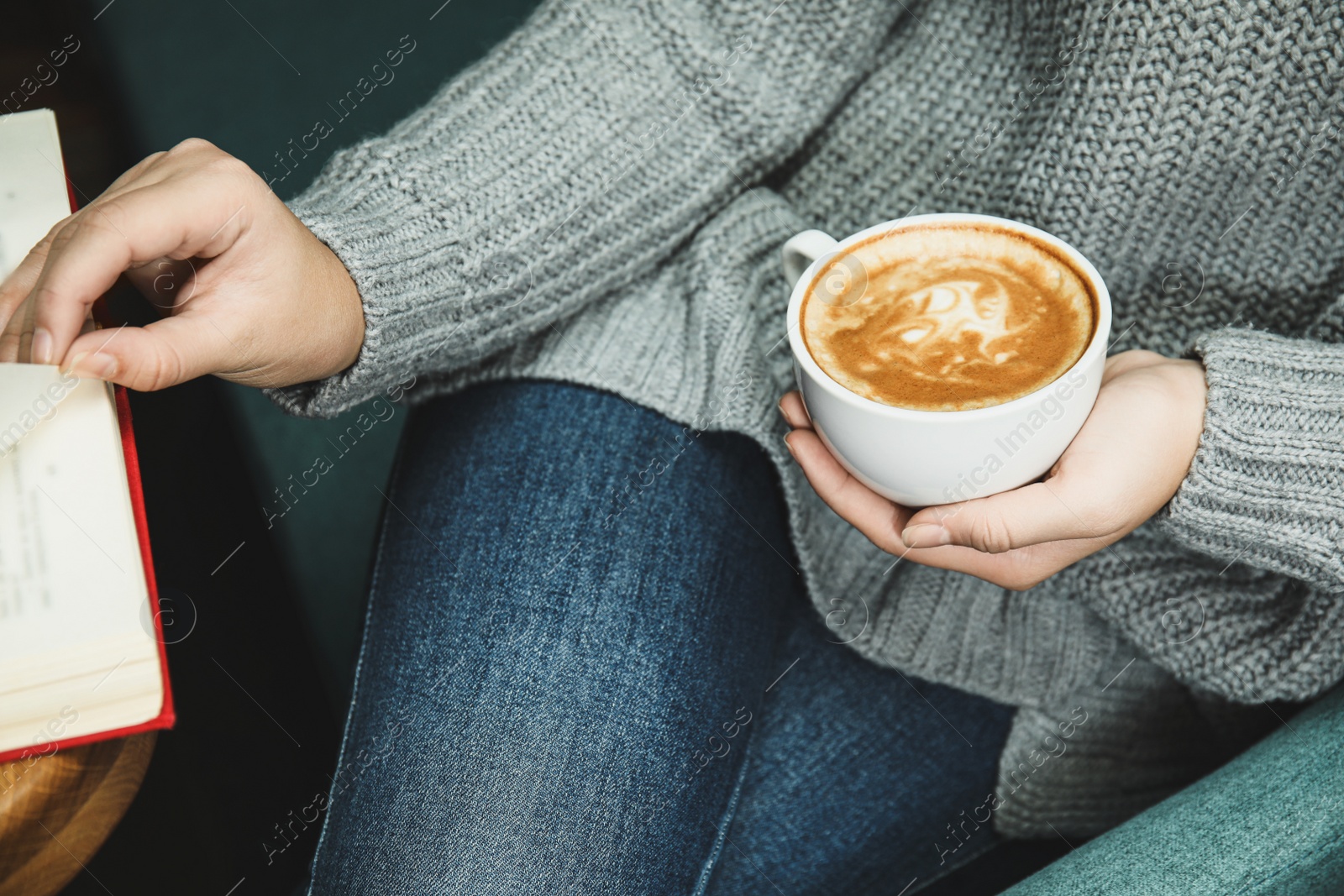 Photo of Woman with cup of coffee reading book at home, closeup