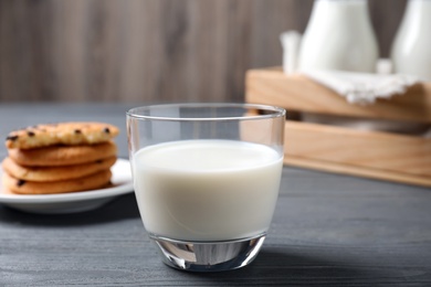 Photo of Glass of delicious milk on grey wooden table