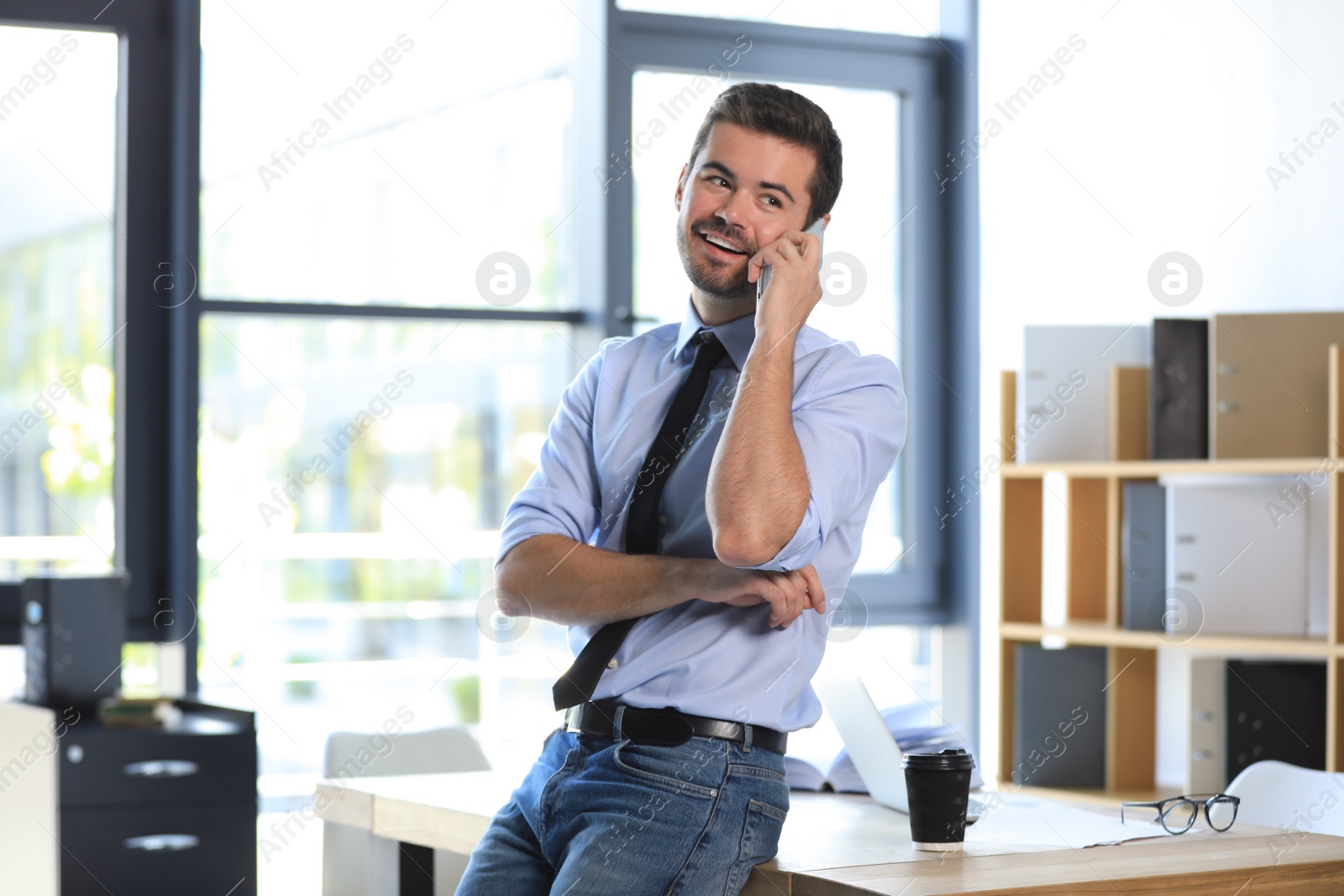 Photo of Male business trainer talking on phone in office