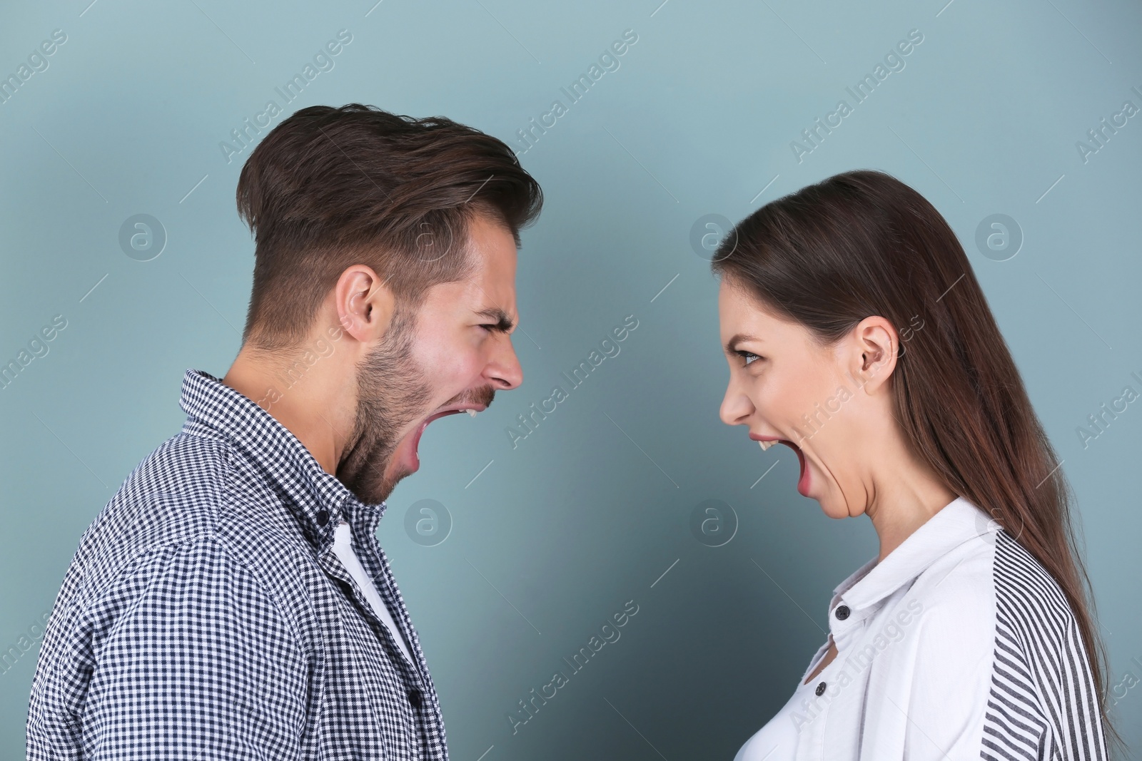Photo of Young couple having argument on color background. Relationship problems