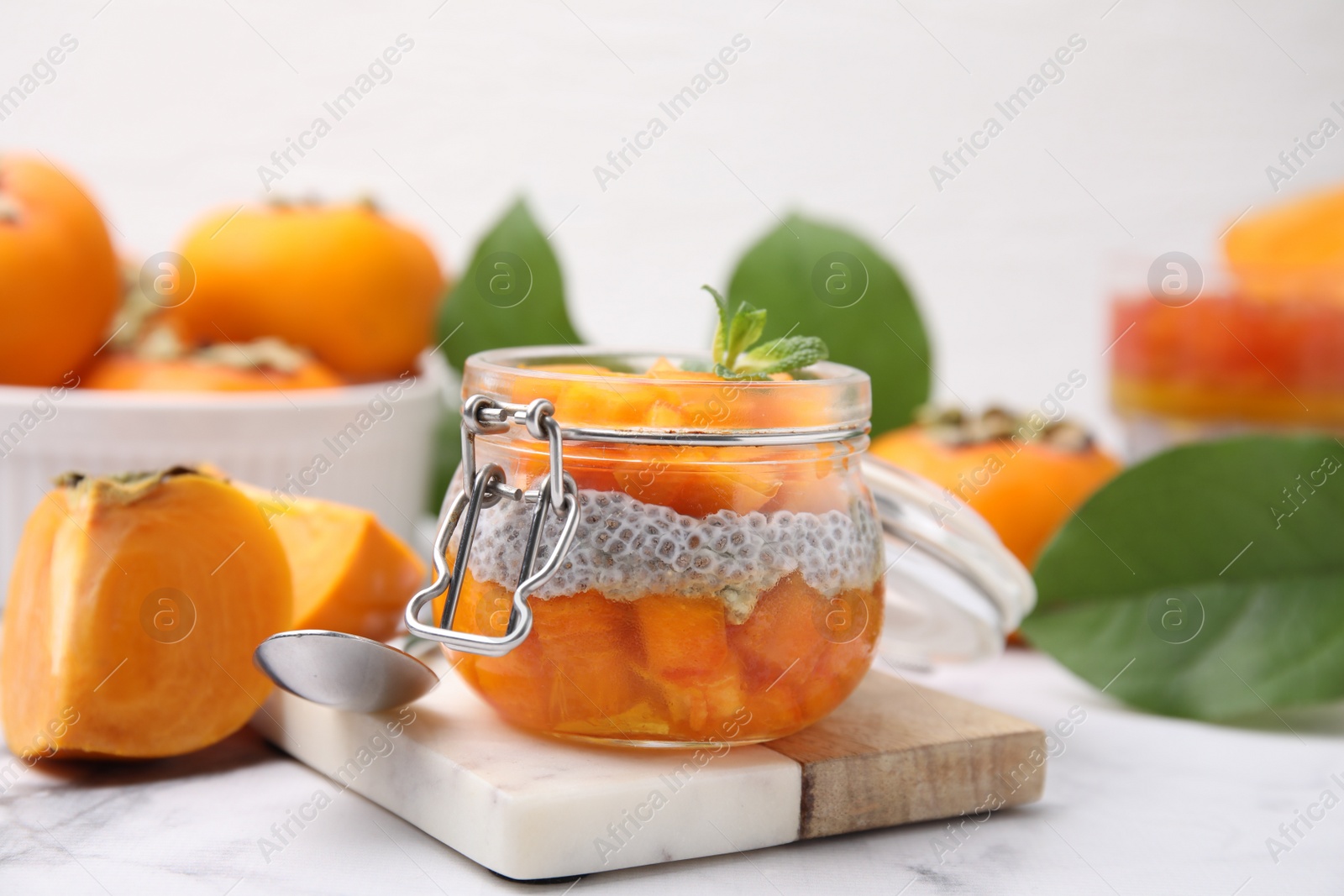 Photo of Delicious dessert with persimmon and chia seeds on table