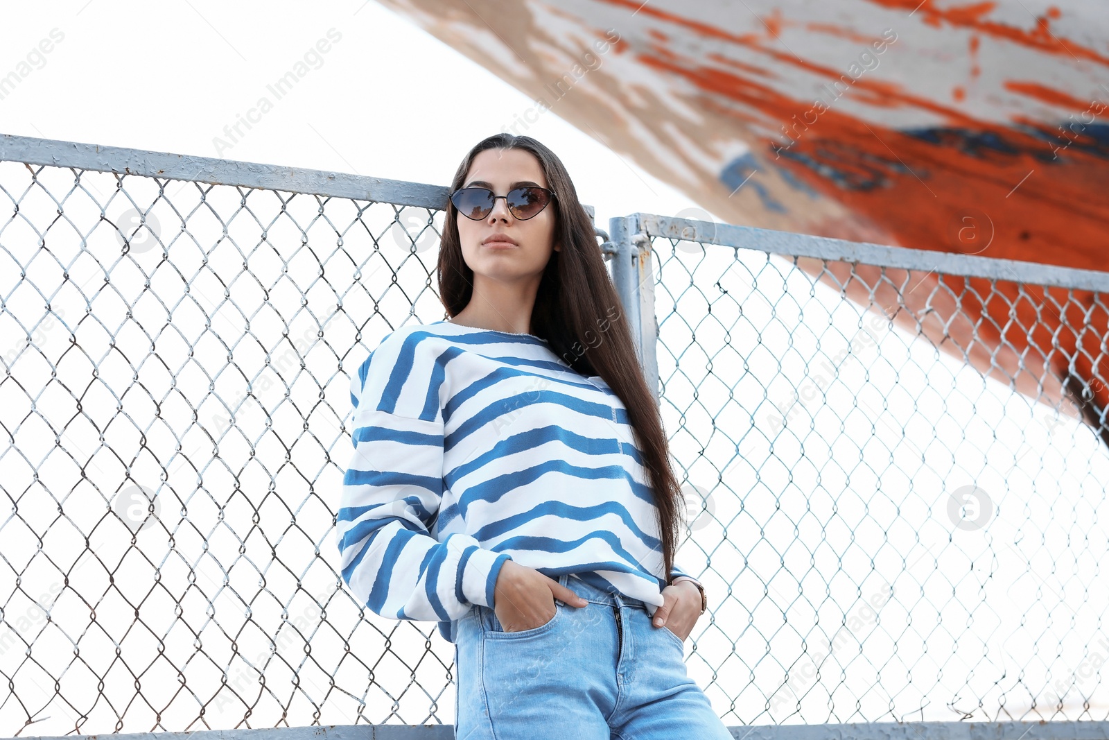 Photo of Young hipster woman in stylish jeans on pier