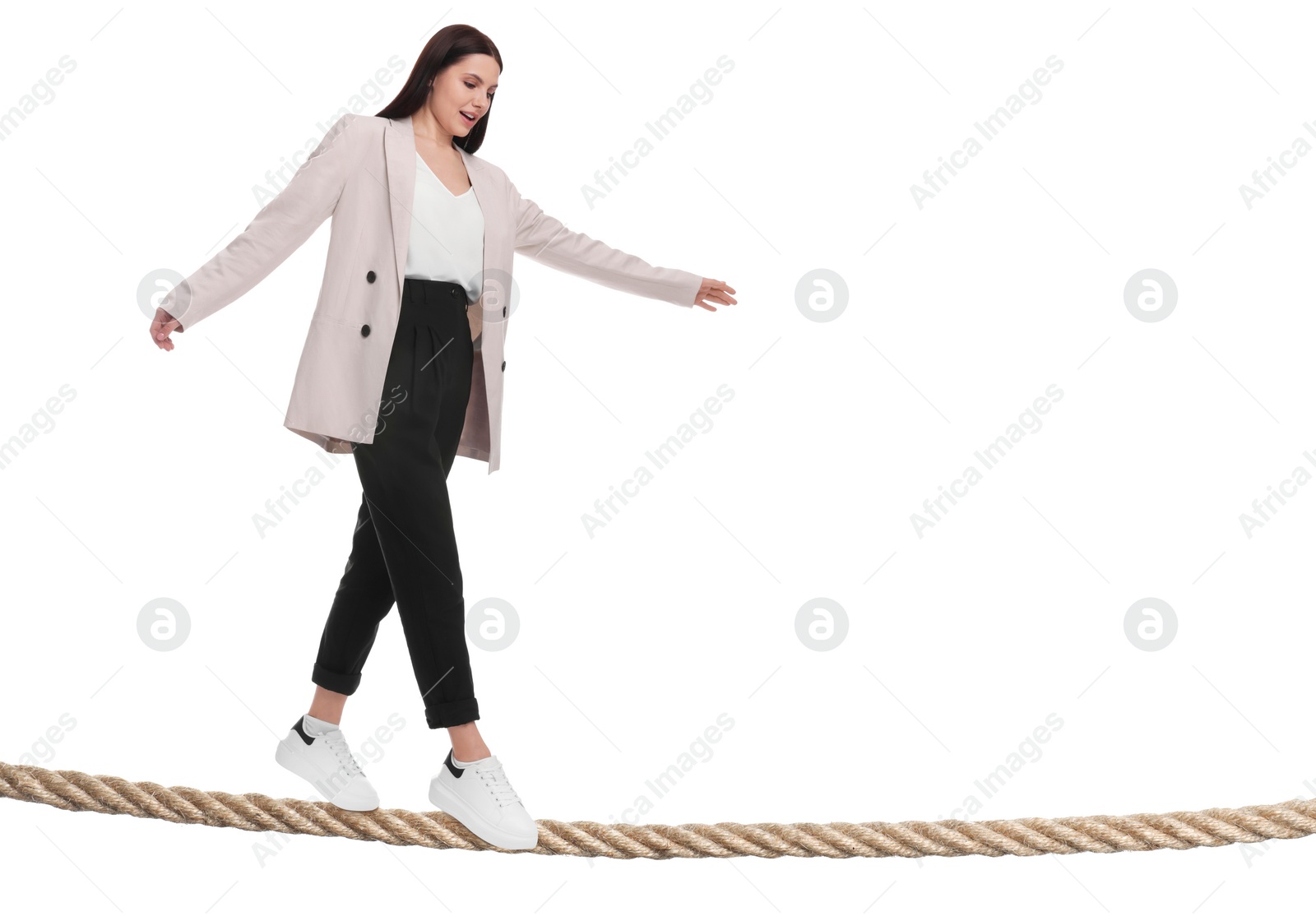 Image of Businesswoman walking rope against white background. Risk or balance concept