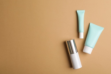 Photo of Set of luxury cosmetic products on light brown background, flat lay. Space for text