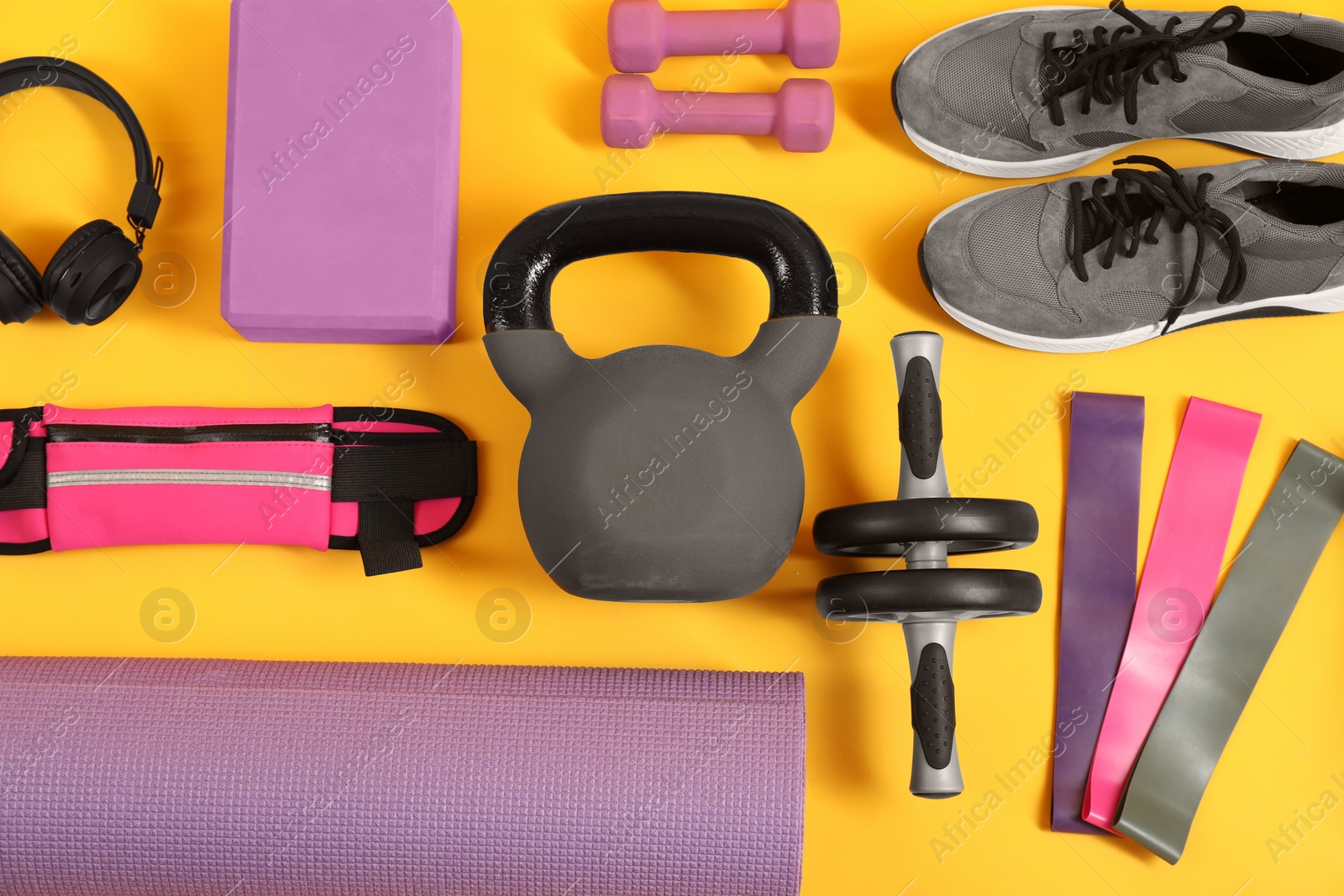 Photo of Different sports equipment on yellow background, flat lay