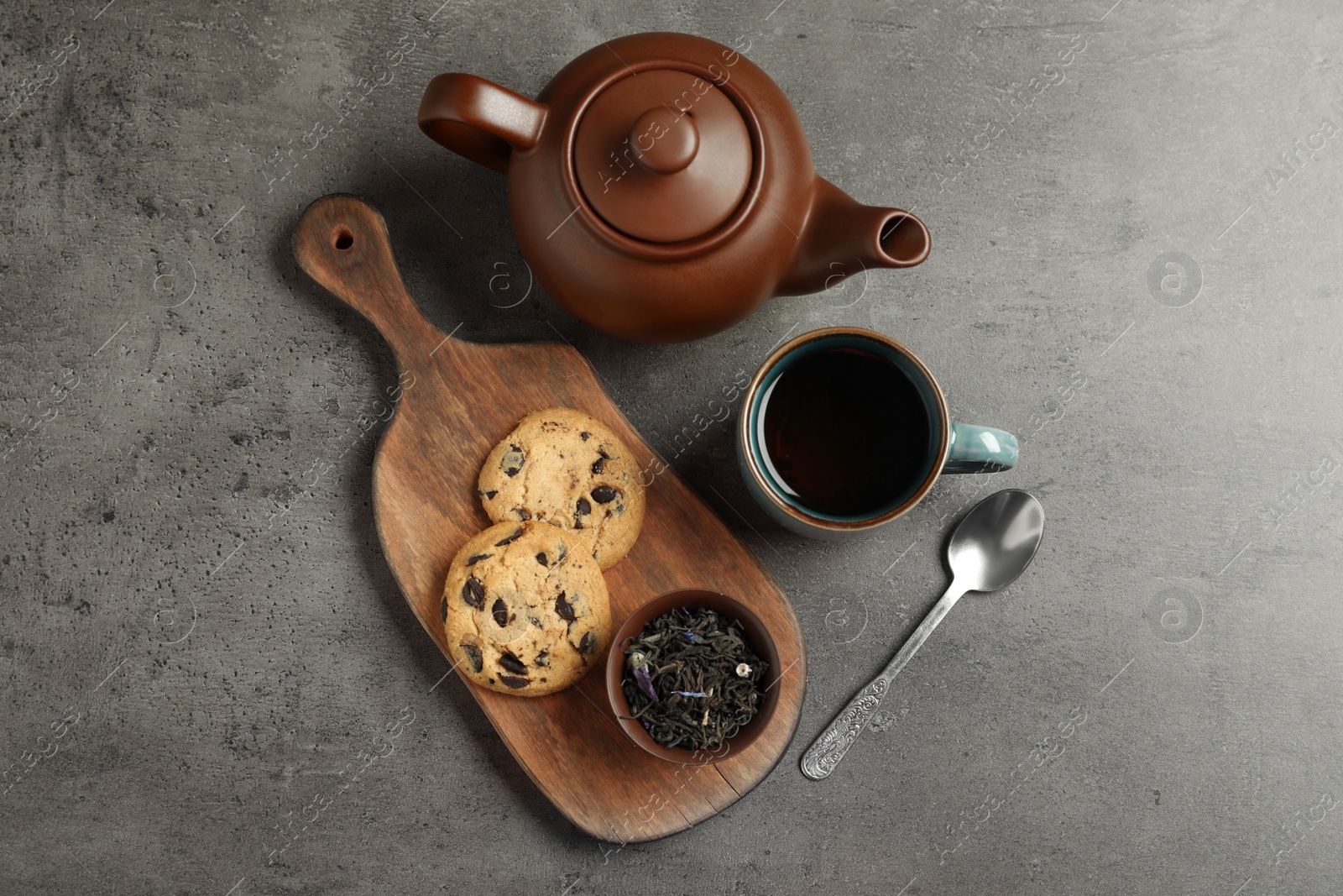 Photo of Flat lay composition with cup of hot aromatic tea and cookies on grey background