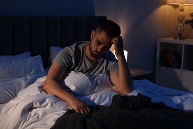 Frustrated man suffering from insomnia in bed