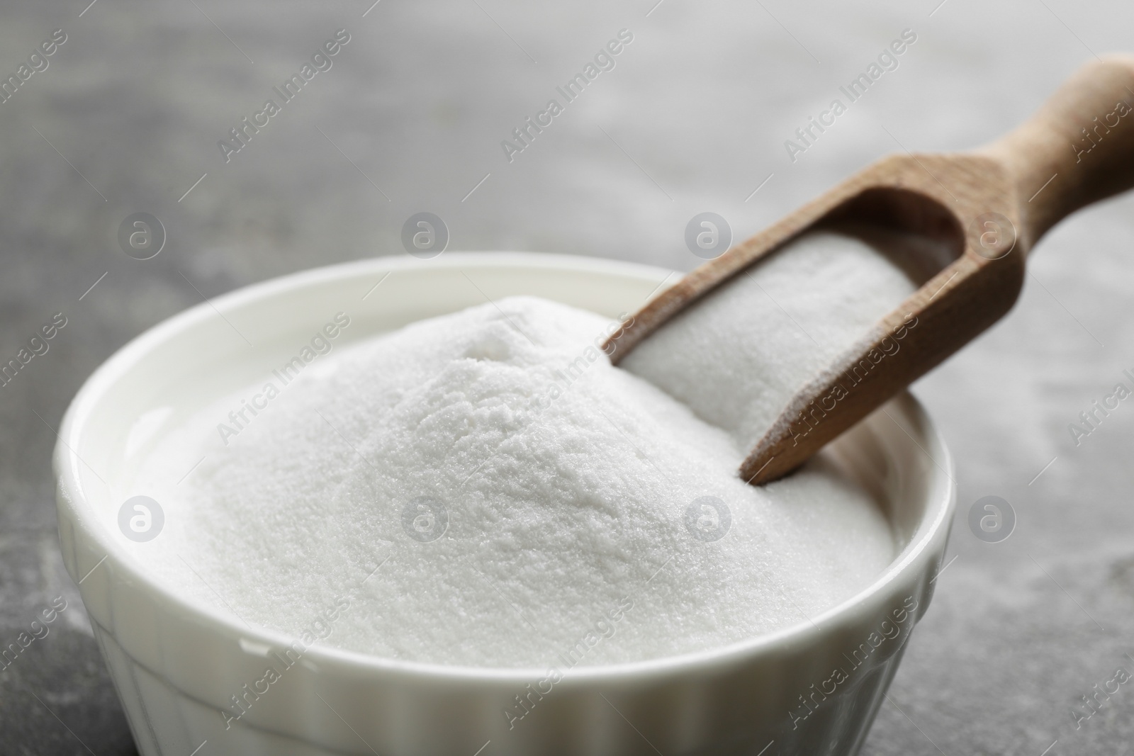 Photo of Baking soda on grey table, closeup view