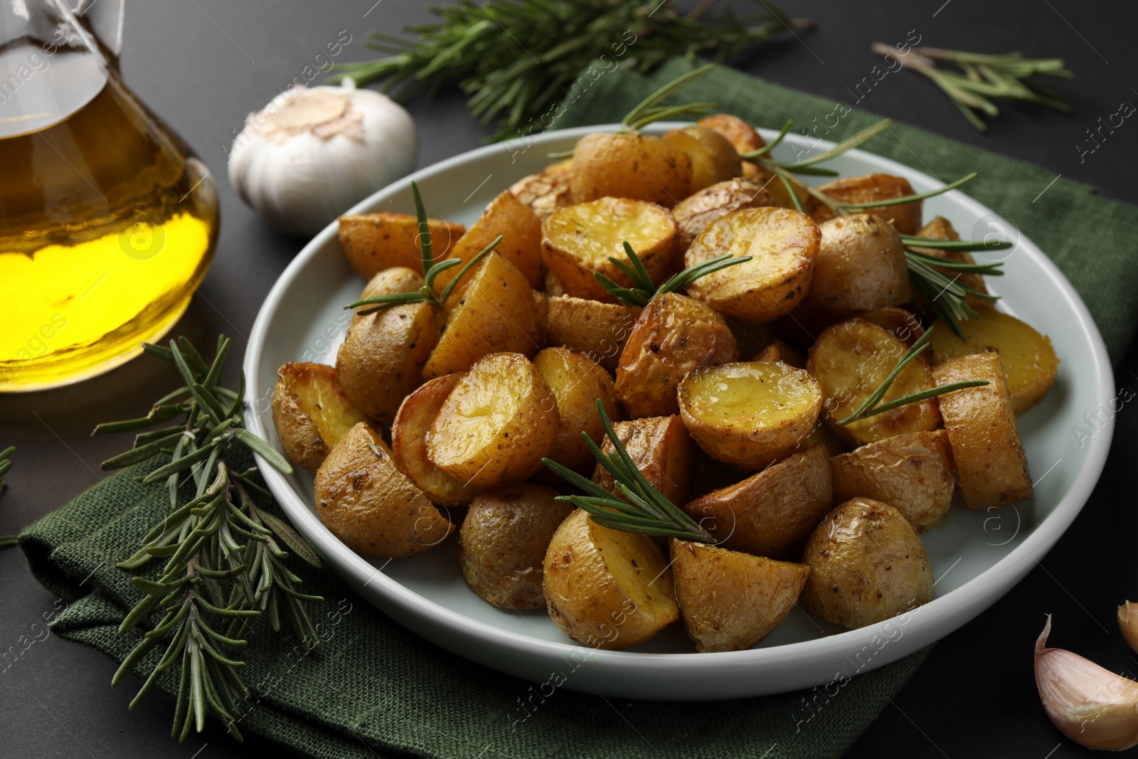 Photo of Delicious baked potatoes with rosemary on table