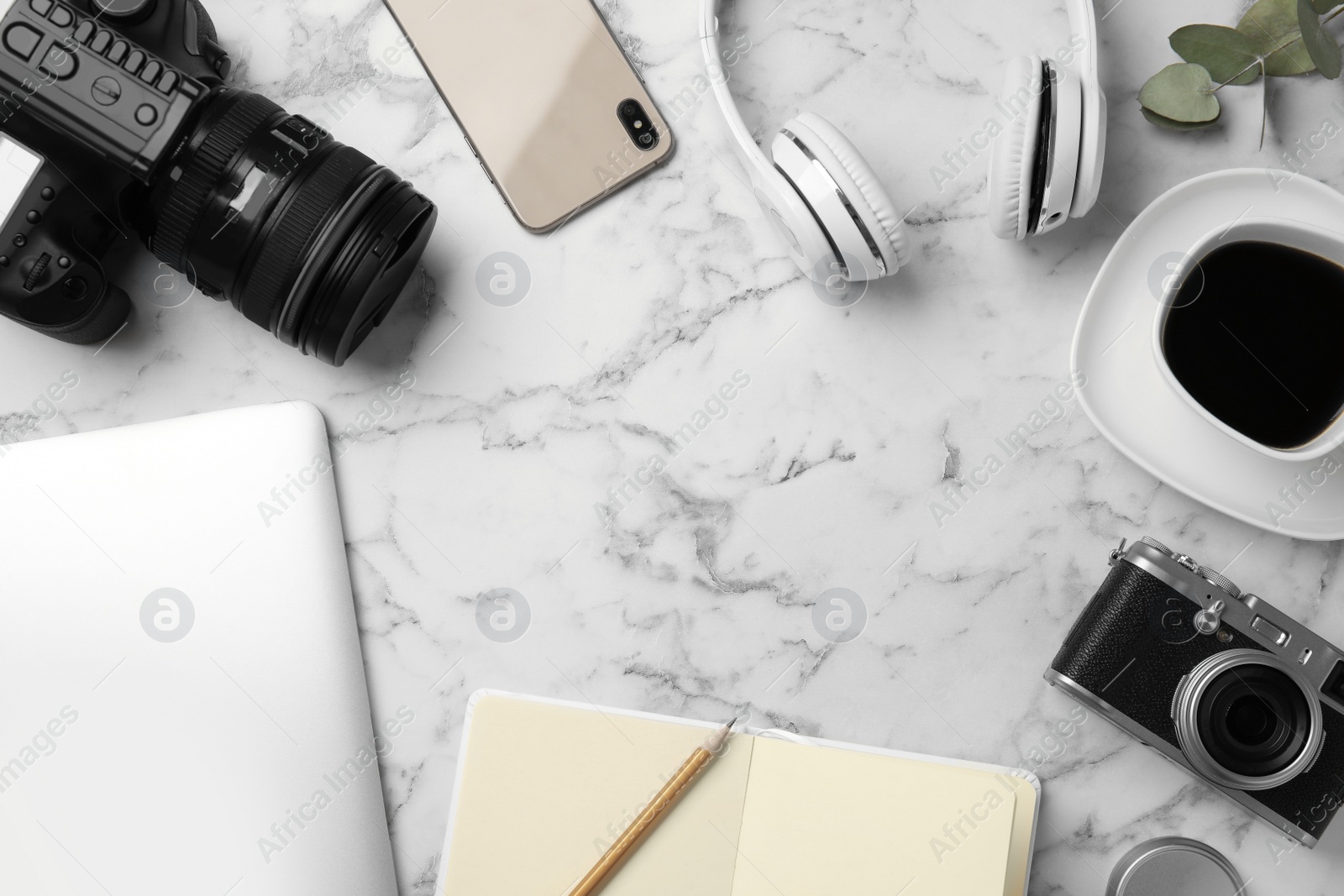 Photo of Flat lay composition with cameras, laptop and smartphone on white marble table, space for text. Designer's workplace