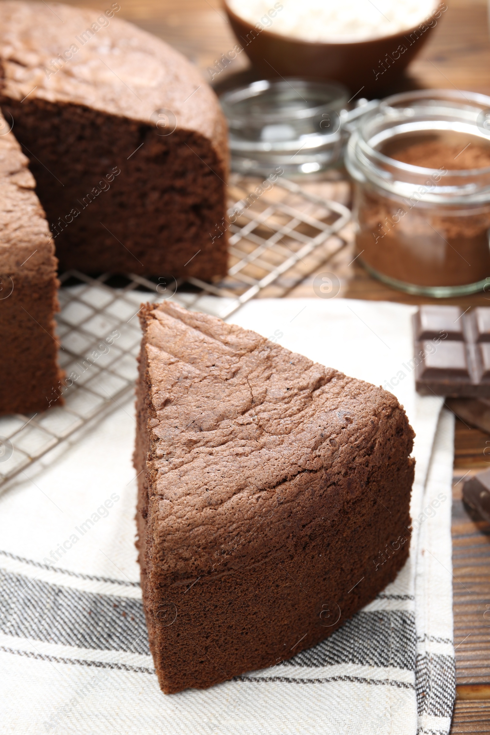 Photo of Piece of tasty chocolate sponge cake on wooden table, closeup