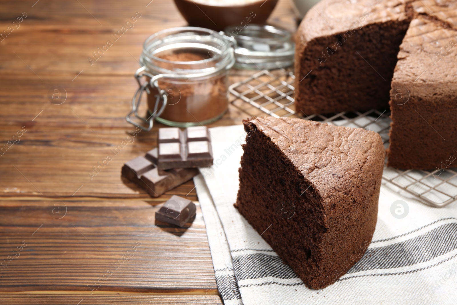 Photo of Cut chocolate sponge cake on wooden table, closeup