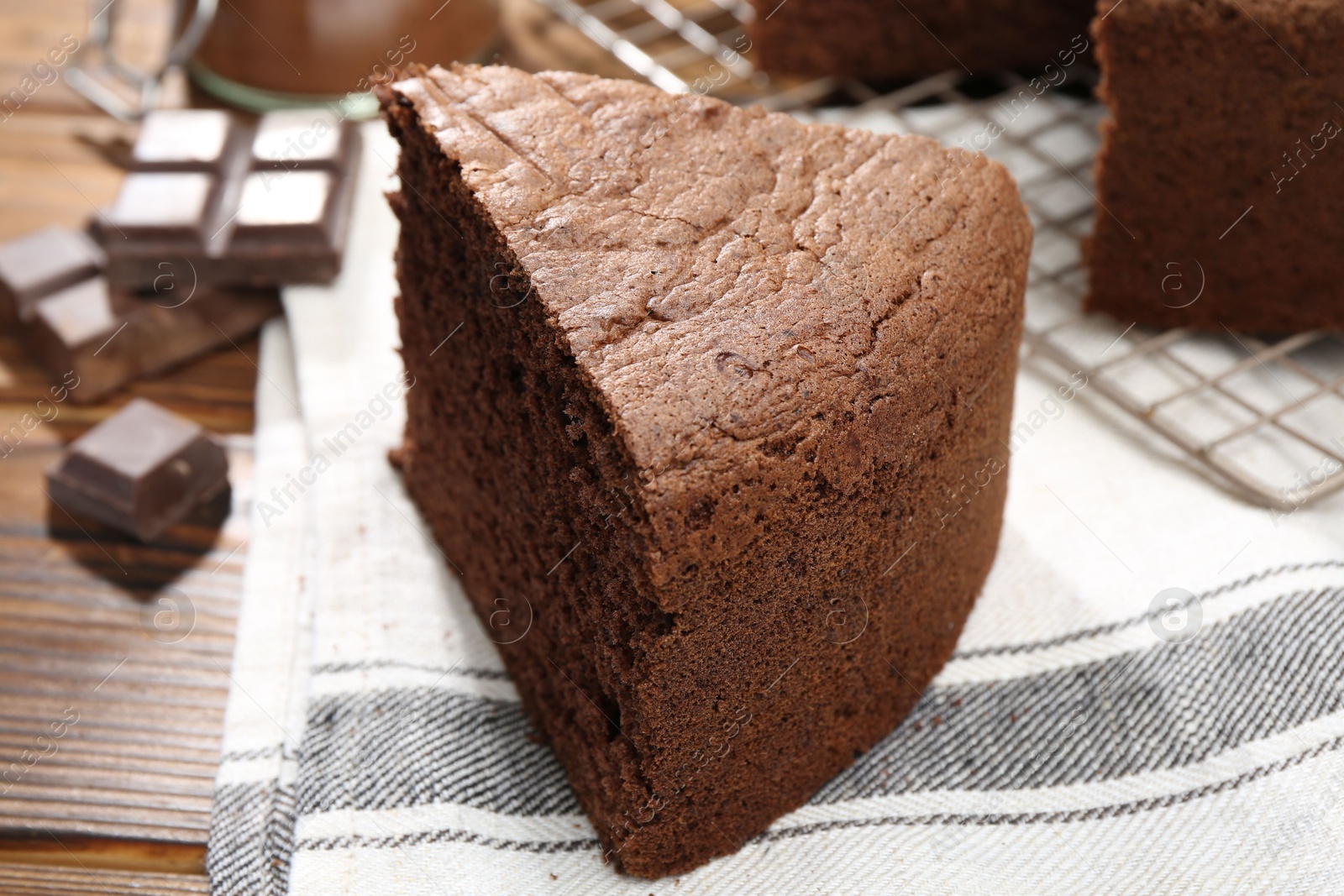 Photo of Piece of tasty chocolate sponge cake on wooden table, closeup