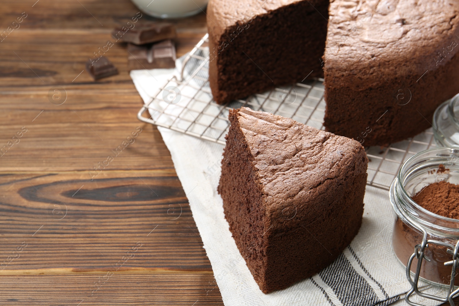 Photo of Cut chocolate sponge cake on wooden table, closeup