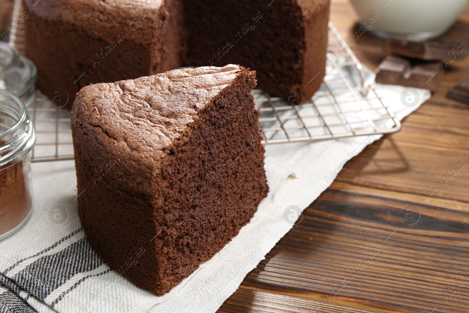 Photo of Piece of tasty chocolate sponge cake on wooden table, closeup