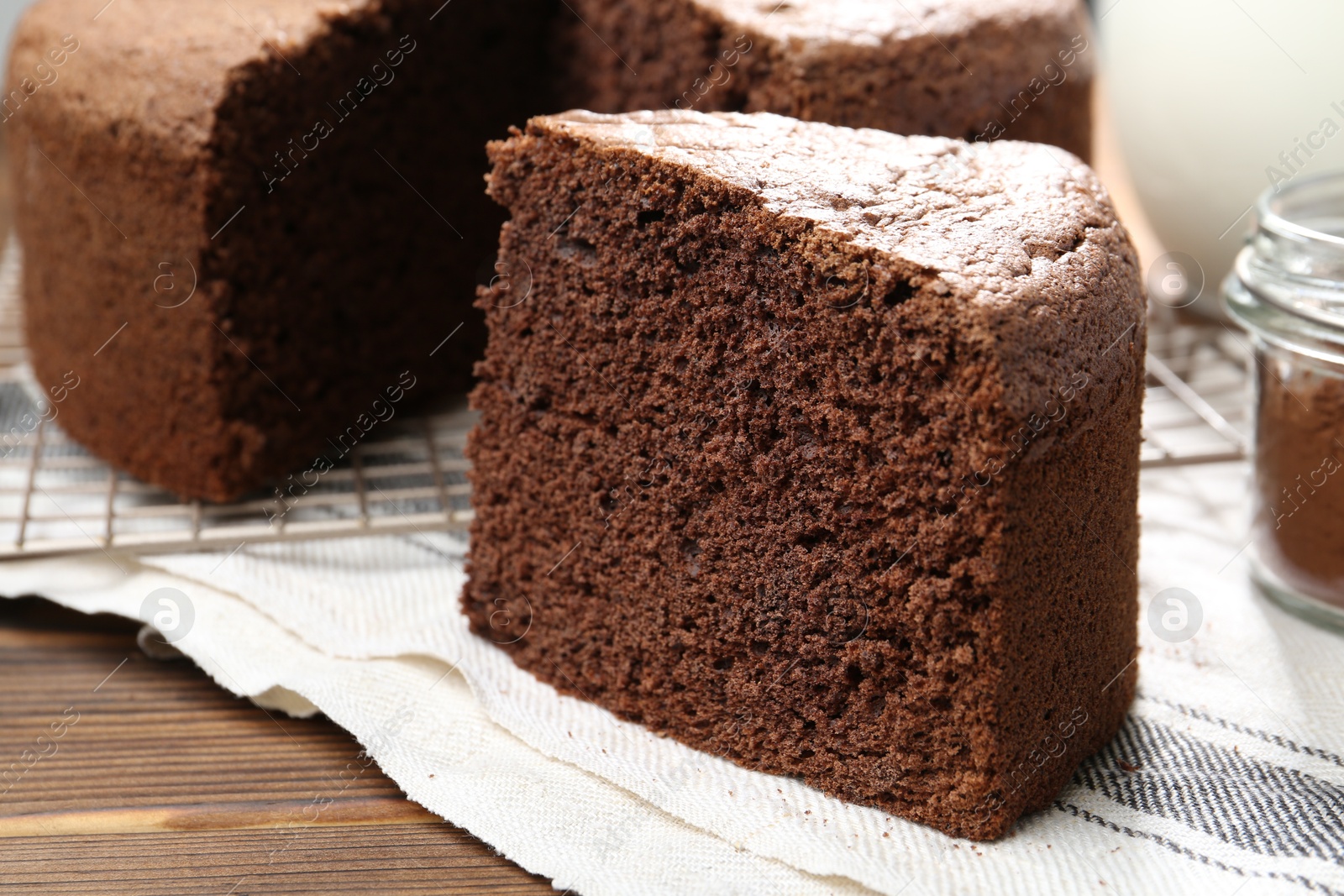 Photo of Piece of tasty chocolate sponge cake on wooden table, closeup