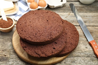 Photo of Cut chocolate sponge cake and ingredients on wooden table