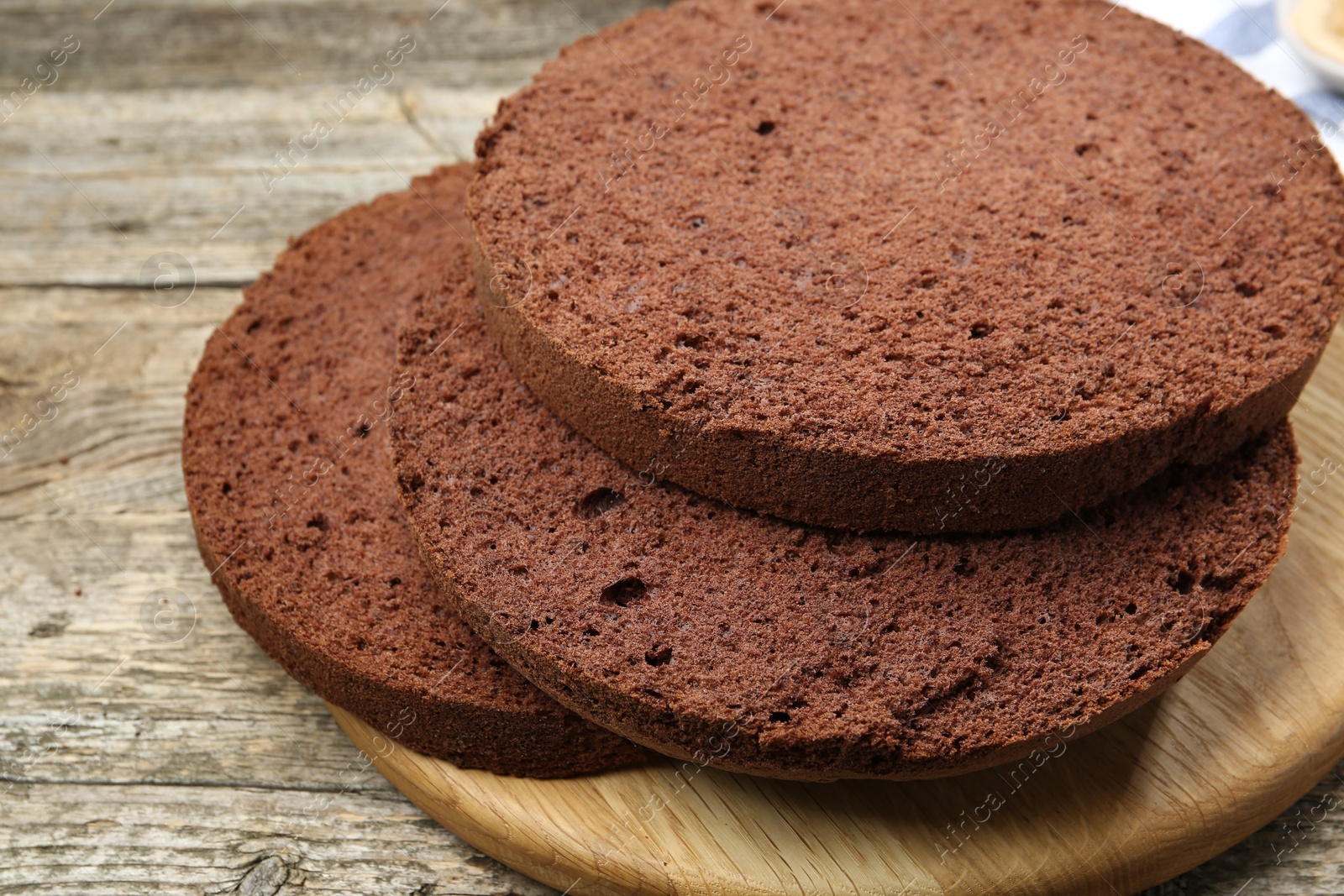 Photo of Cut chocolate sponge cake on wooden table, closeup