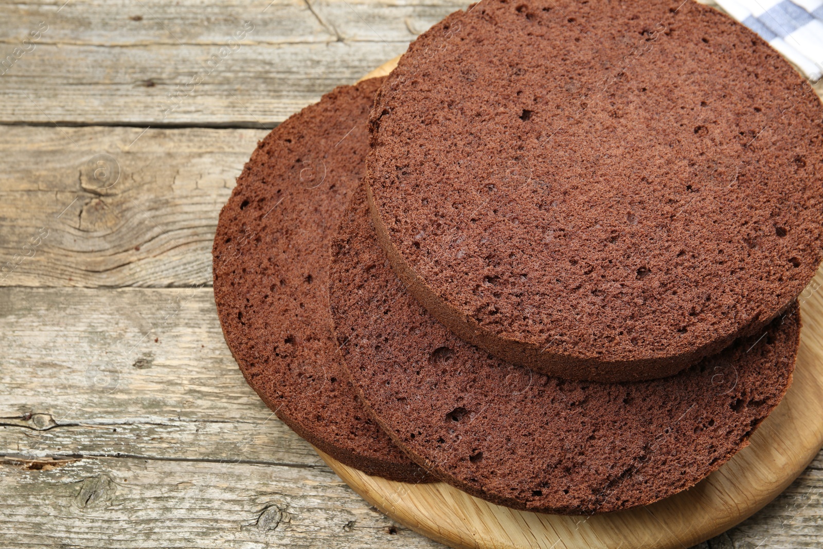 Photo of Cut chocolate sponge cake on wooden table, closeup