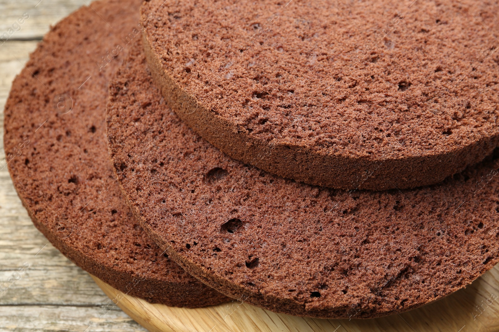 Photo of Cut chocolate sponge cake on wooden table, closeup