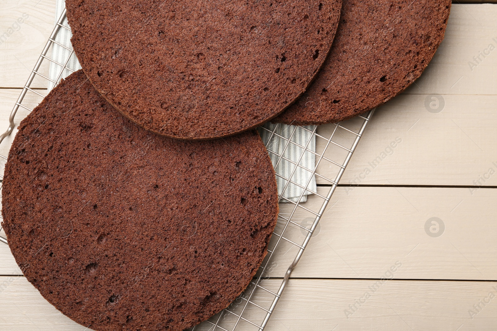 Photo of Cut chocolate sponge cake on wooden table, top view