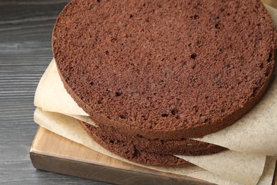 Photo of Cut chocolate sponge cake on wooden table, closeup