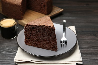 Photo of Piece of tasty chocolate sponge cake served on wooden table, closeup