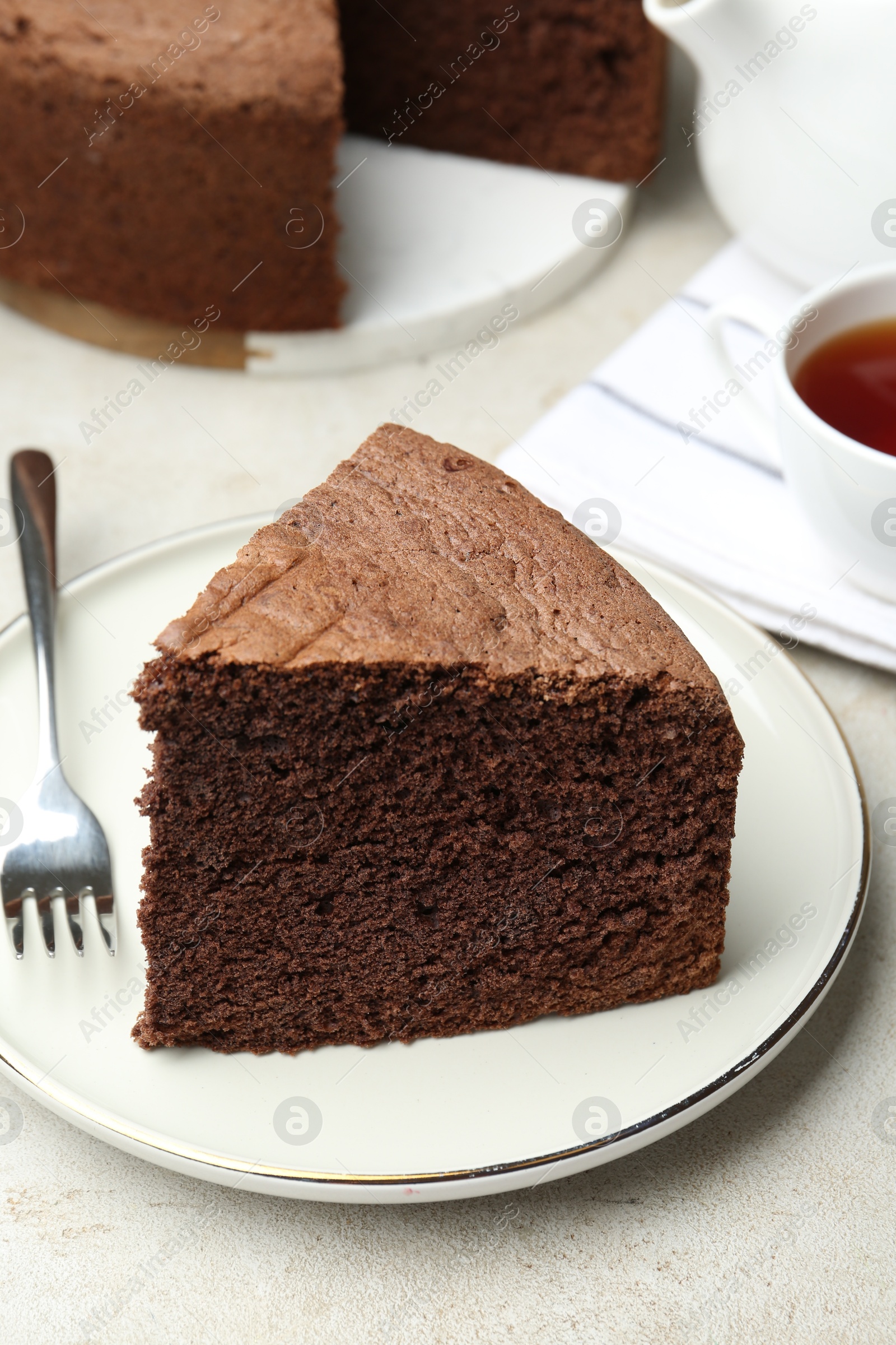 Photo of Piece of tasty chocolate sponge cake served on light table