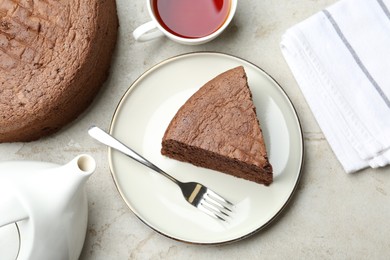 Photo of Piece of tasty chocolate sponge cake served on light table, flat lay