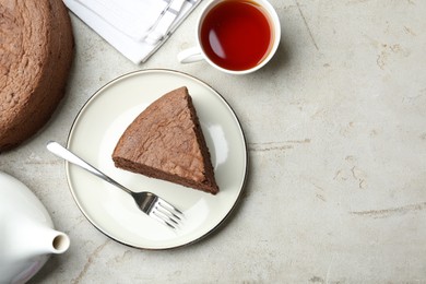 Photo of Piece of tasty chocolate sponge cake served on light table, flat lay. Space for text