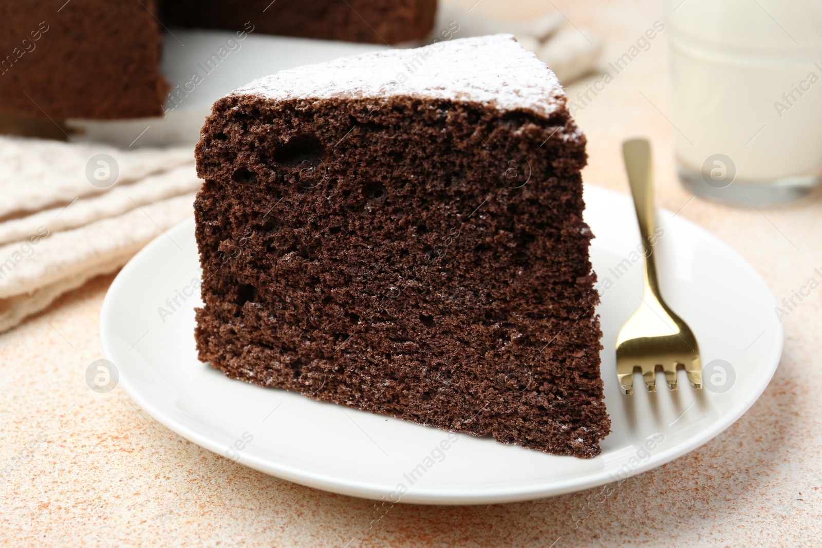 Photo of Piece of tasty chocolate sponge cake served on light table, closeup