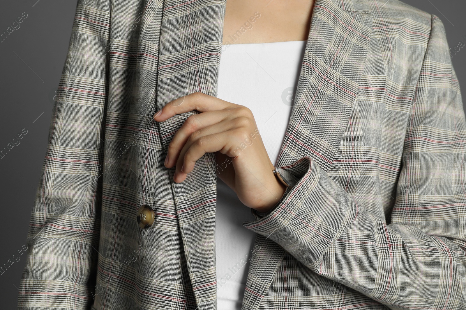 Photo of Beautiful woman with stylish jacket and watch on grey background, closeup