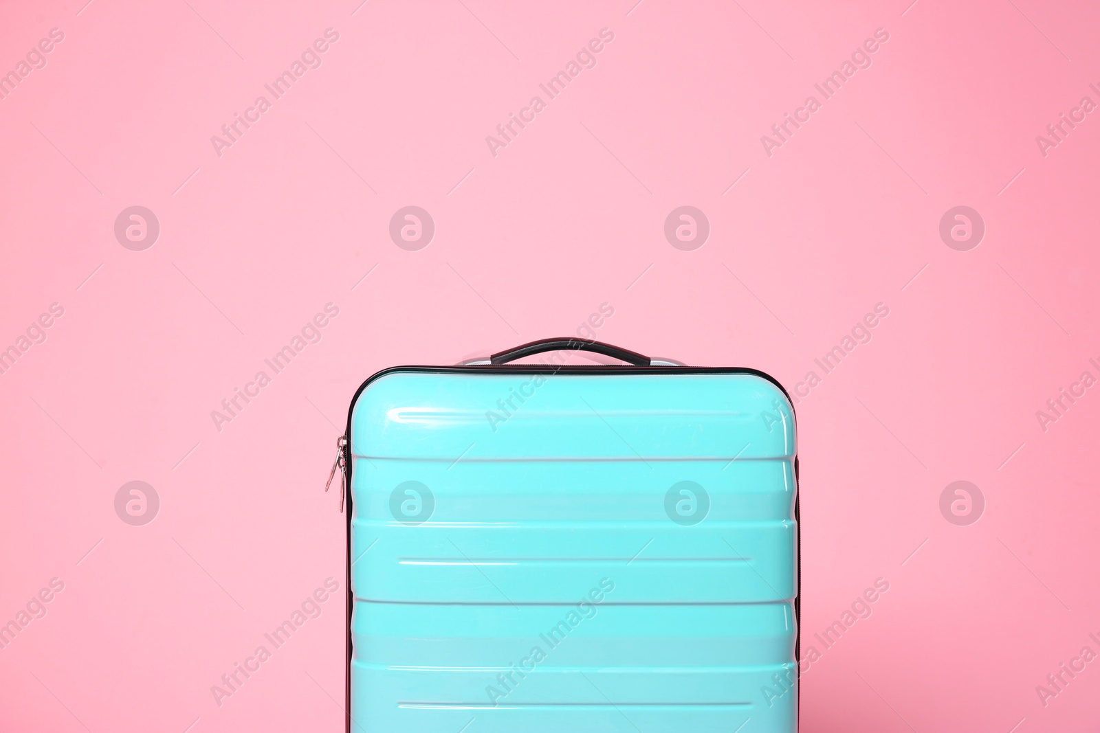 Photo of One new turquoise suitcase on pink background