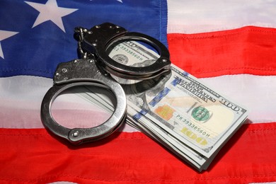 Handcuffs with dollar banknotes on American flag