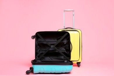 Photo of Two new color suitcases on pink background