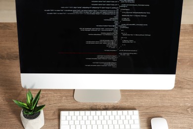 Photo of Programmer's workplace. Modern computer with unfinished code on desk, above view