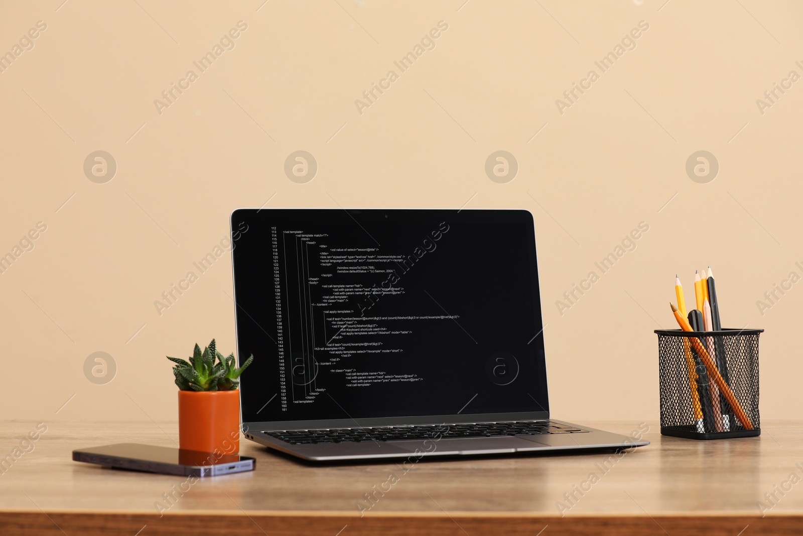 Photo of Programmer's workplace. Modern laptop with unfinished code on desk