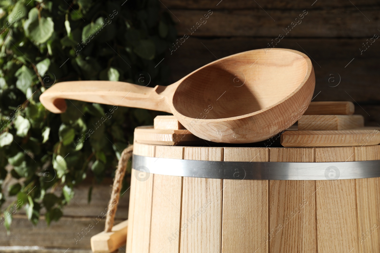 Photo of Sauna equipment. Wooden bucket and ladle indoors, closeup