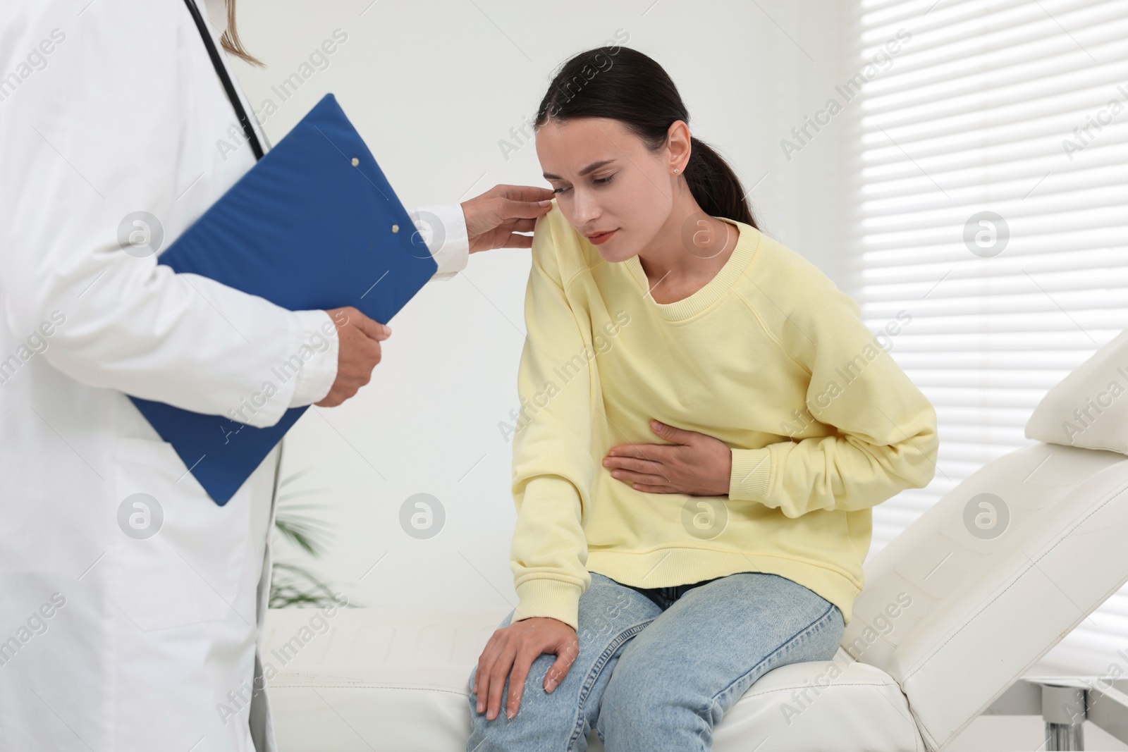 Photo of Doctor consulting patient with stomach pain in hospital, closeup