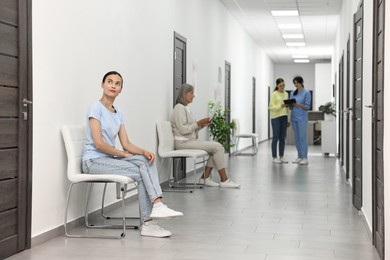 Photo of Patients waiting for appointment and doctor in hospital hallway, selective focus