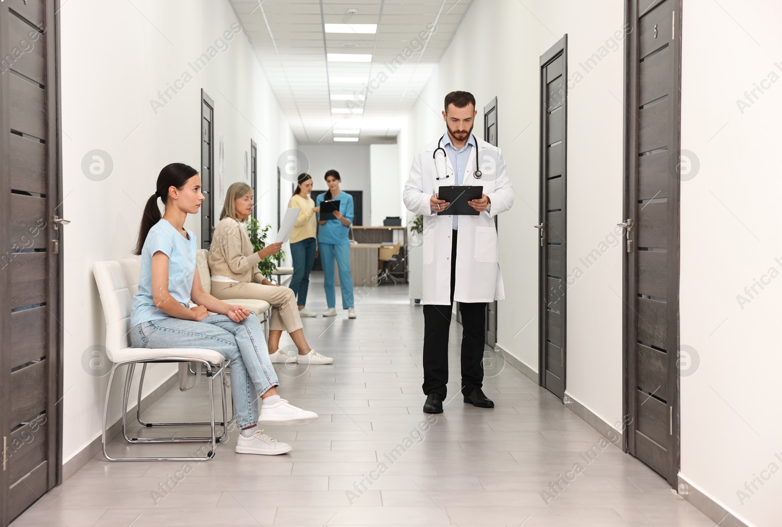 Photo of Patients waiting for appointment and doctors in hospital hallway, selective focus