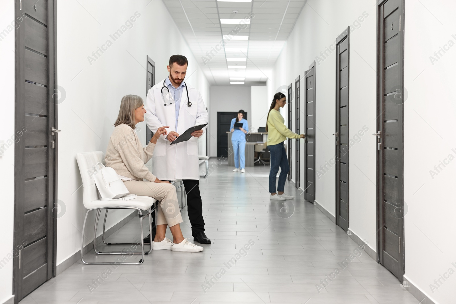 Photo of Patients waiting for appointment and doctors in hospital hallway, selective focus