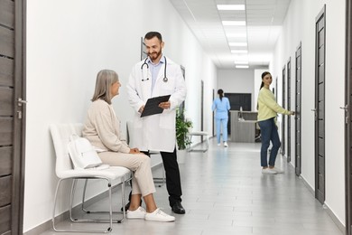 Photo of Patients with doctors in hospital hallway, selective focus